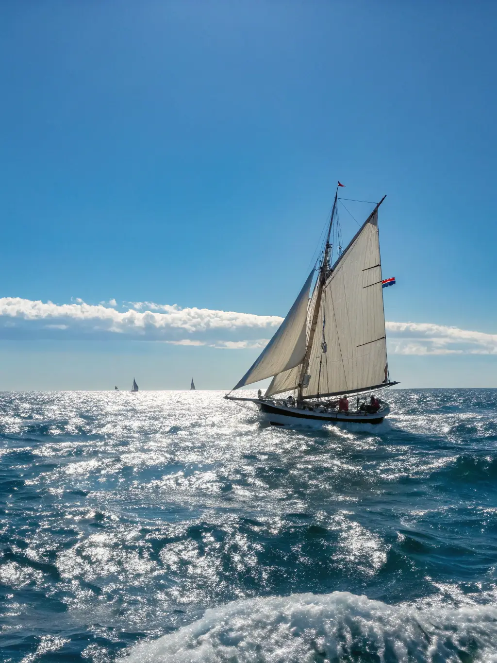 A picture of a modern sailboat gliding smoothly across the water, highlighting the thrill and enjoyment of sailing.